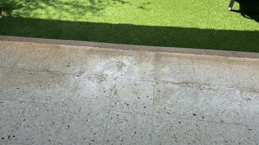 Piso de terrazo exterior opaco y manchado antes de recibir mantenimiento